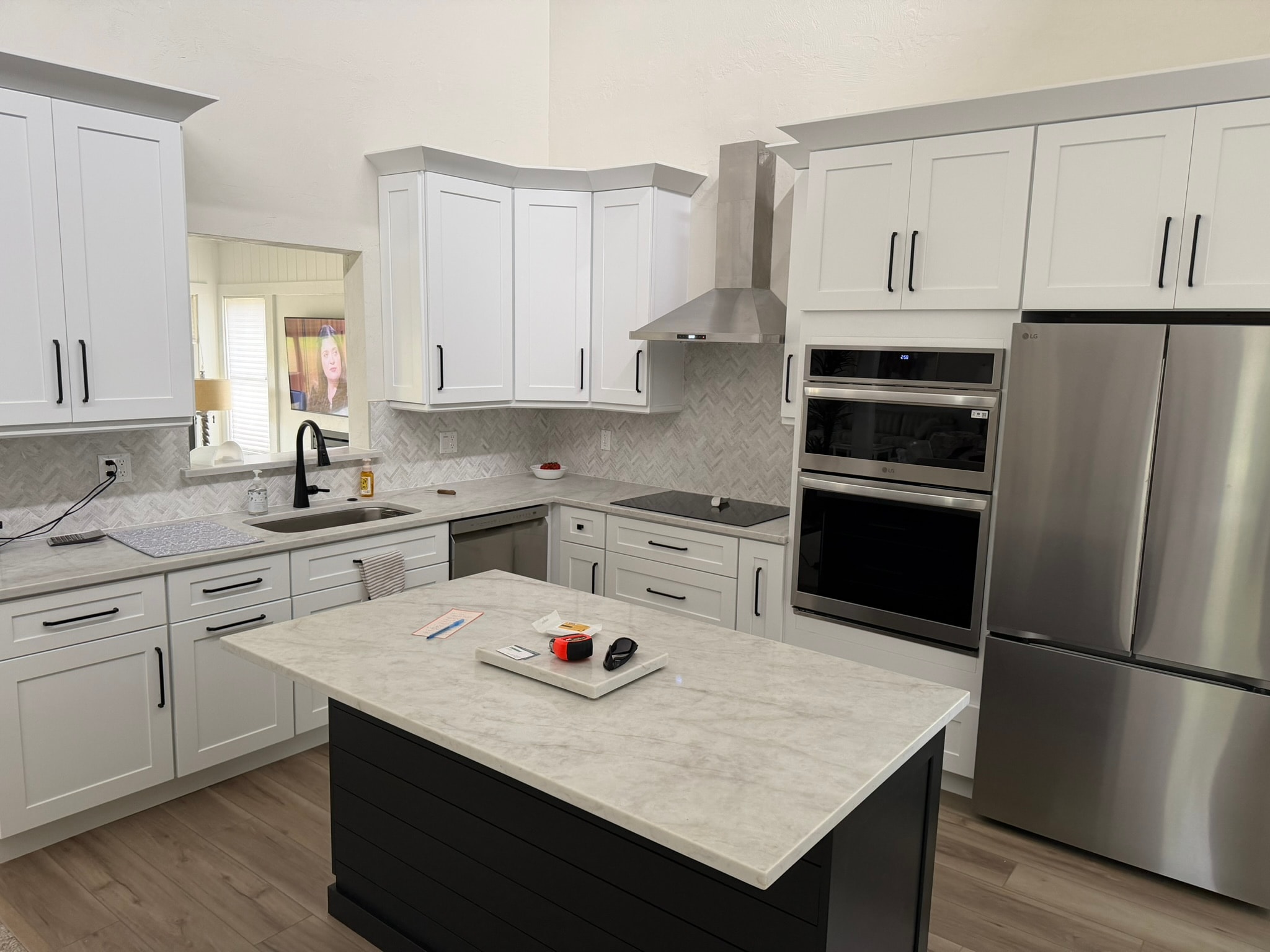 Pelican Bay Condo after renovation — new kitchen with white shaker cabinets and marble counters