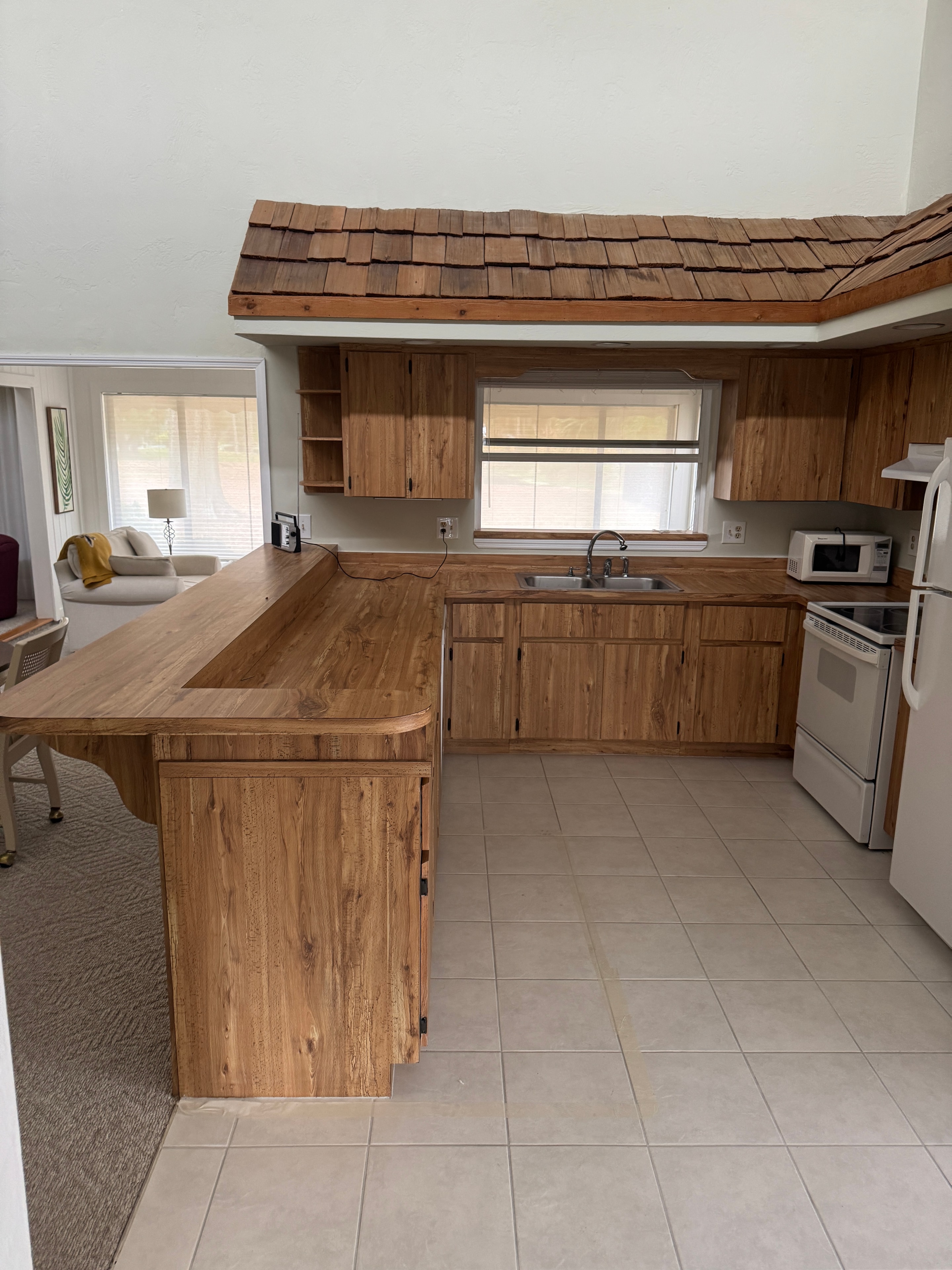 Pelican Bay Condo before renovation — original kitchen and living area